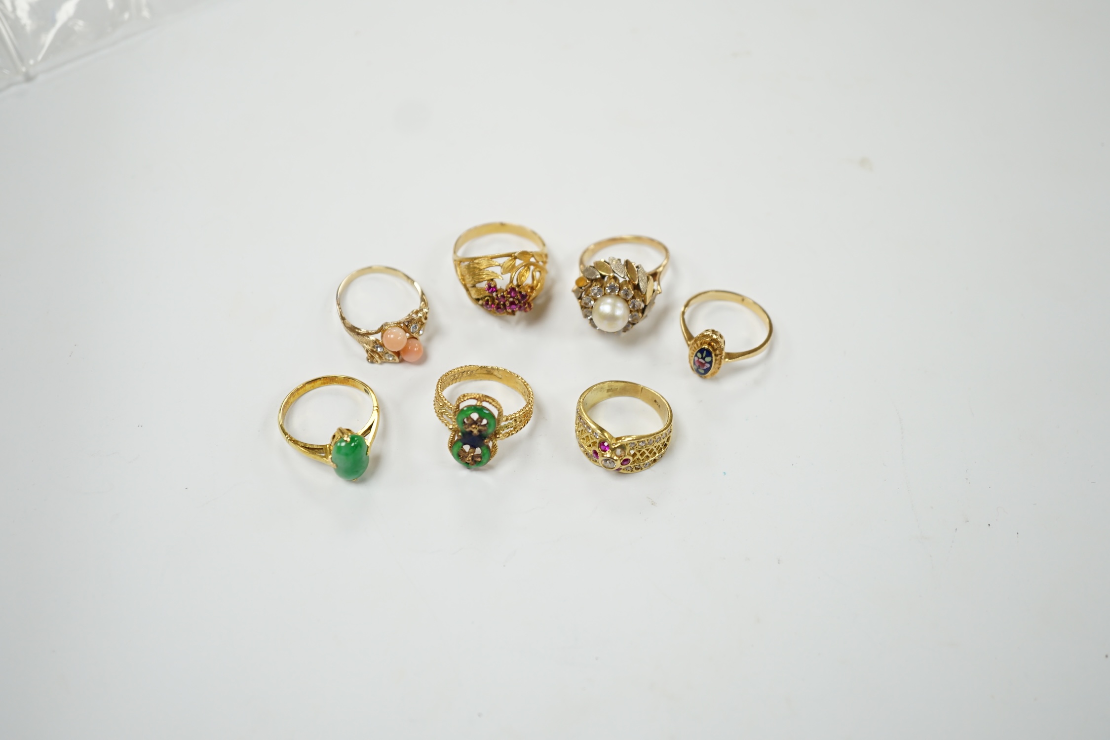 A Middle Eastern 750 yellow metal and two colour enamel up-finger ring, size M, a Chinese 750 yellow metal and gem set cluster ring, gross weight 9.4 grams, a 14k and jade set ring, gross weight 2.8 grams and three assor